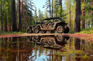 ITP MT911 and Terra Hook tires and rugged frame of an UTV reflected in the murky depths of a puddle.